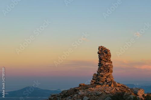 Mountain peak stone pile at sunset photo