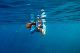 Woman making photo underwater. Girl snorkeling in full-face mask. Snorkel with fish under water surface