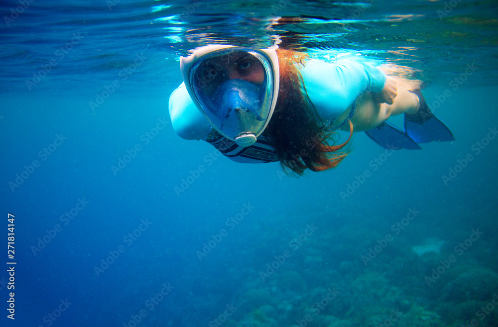 Woman swim in blue sea. Girl snorkeling in full-face mask. Snorkel closeup underwater photo. Snorkeling mask undersea Woman swim in blue sea. Girl snorkeling in full-face mask. Snorkel closeup underwater photo. Snorkeling mask undersea