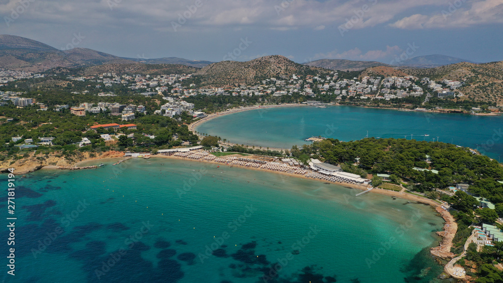 Aerial drone bird's eye panoramic photo of famous celebrity sandy beach of Astir or Asteras in south Athens riviera with turquoise clear waters, Vouliagmeni, Greece