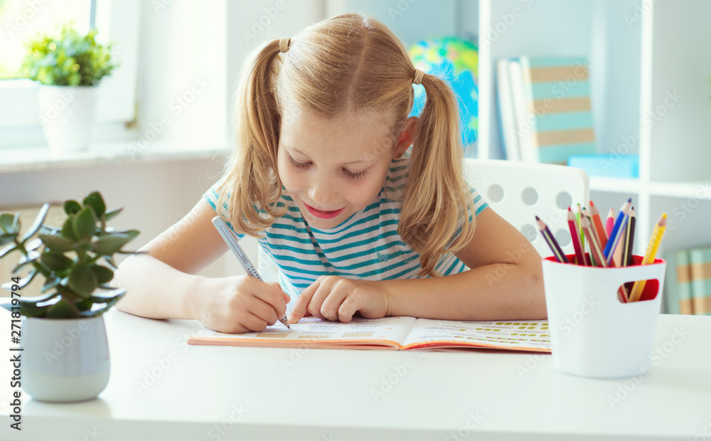 Portrait of schoolgirl at classroom writing at the table Portrait of schoolgirl at classroom writing at the table
