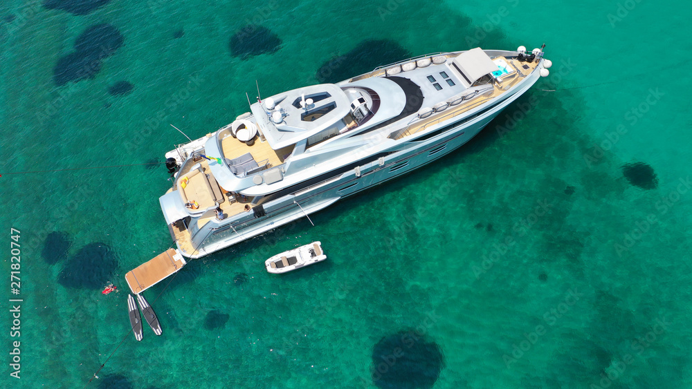 Aerial drone top view photo of large yacht - boat docked in tropical exotic paradise bay with emerald open ocean