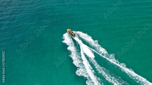 Aerial drone top view photo of jet ski cruising in high speed in emerald exotic tropical bay © aerial-drone