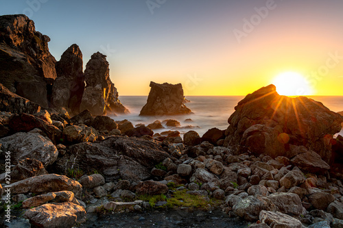 Spectacular sunset with sea stacks and rocky shore long exposure clear sky