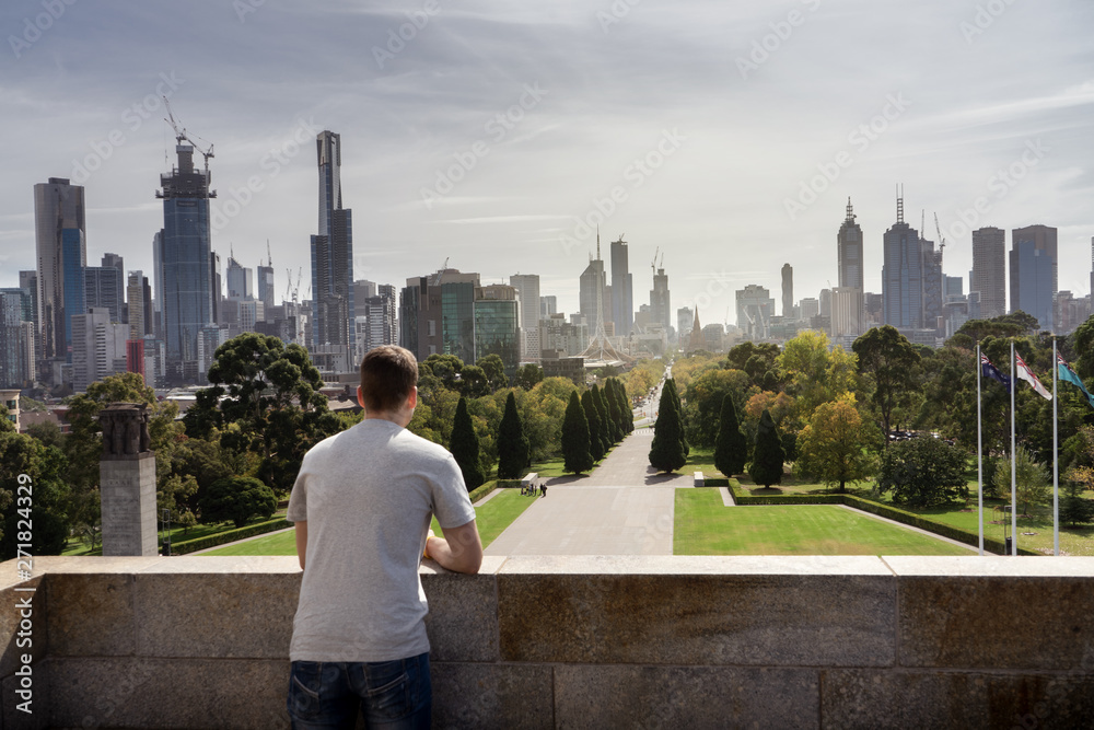 Naklejka premium Boy looking to Melbourne City skyline Australia