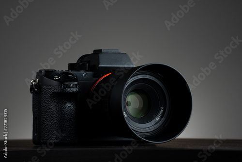 Mirrorless photo camera on wood table isolated gray background