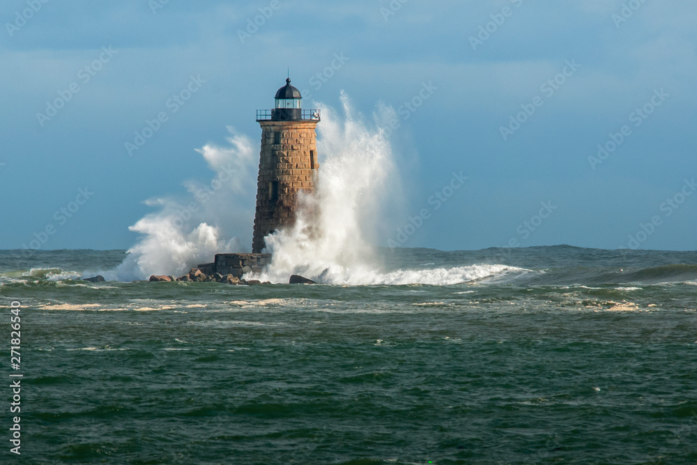 Huge Waves Surround Whaleback Lighthouse as Sun breaks Through Clouds in Maine in New England