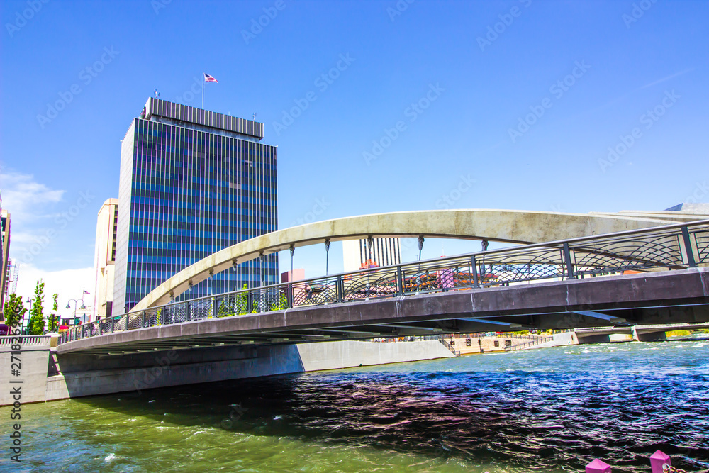 Obraz premium Arched Bridge Over River Into Downtown