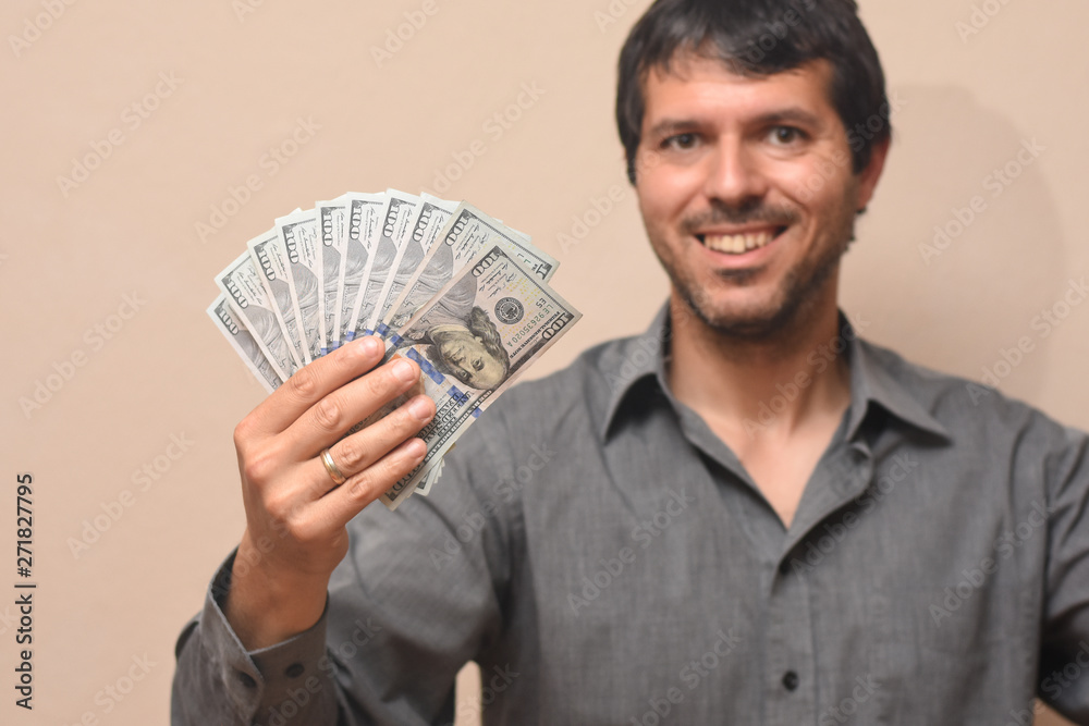Concept of success, Young businessman with lot of money. Pile of dollars in a man hand Concept of success, Young businessman with lot of money. Pile of dollars in a man hand