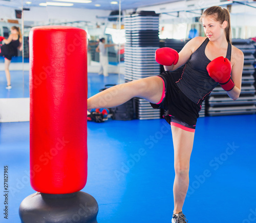 Woman boxer is training kick in box gym. © JackF
