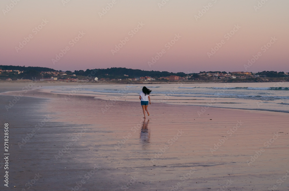 Woman running on the beach of La Lanzada, O Grove, Pontevedra, Galicia, Spain. No people.