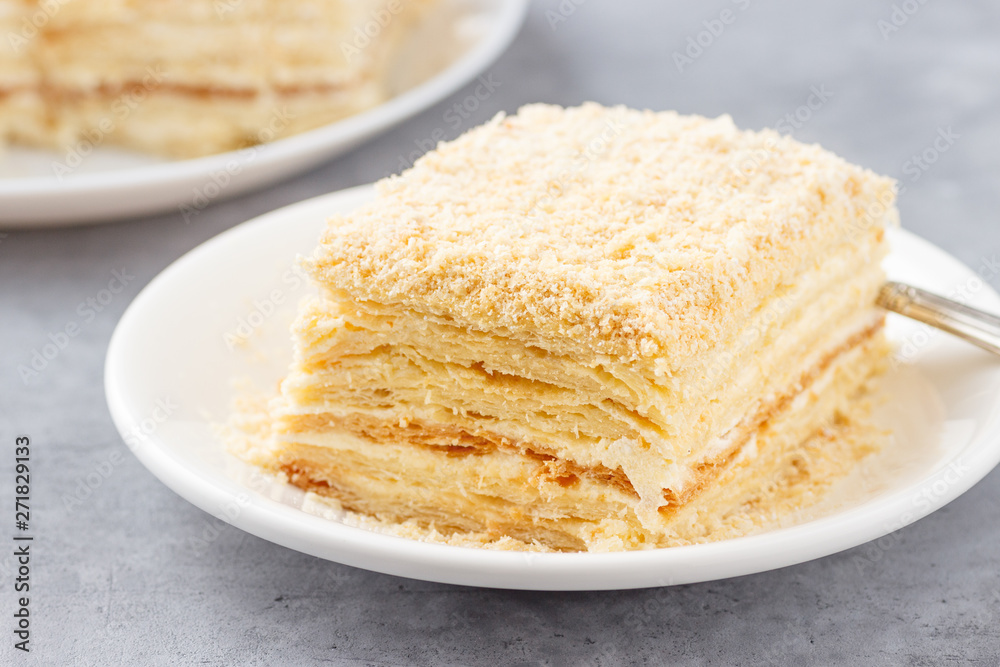 Layered cake with cream Napoleon millefeuille vanilla slice on a white plate.