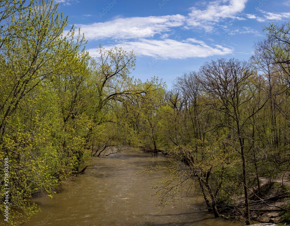 Fast moving North branch of the Chicago River in early Spring with bright blue sky overhead Fast moving North branch of the Chicago River in early Spring with bright blue sky overhead