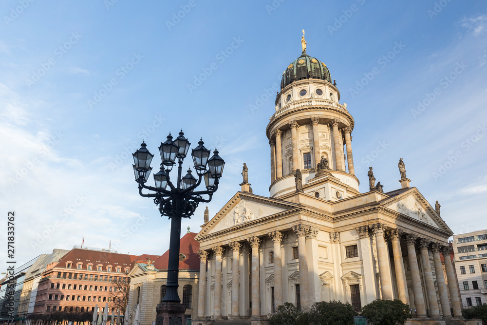Old streetlight and Französischer Dom (French Cathedral) at the Gendarmenmarkt Square in Berlin, Germany, on a sunny morning.
