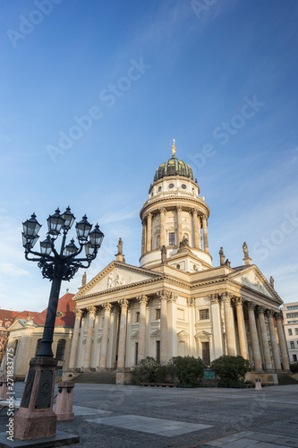 Old streetlight and Französischer Dom (French Cathedral) at the Gendarmenmarkt Square in Berlin, Germany, on a sunny morning. Copy space.