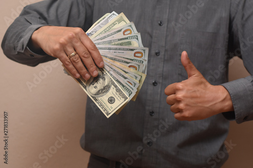 Concept of success, Young businessman with lot of money. Pile of dollars in a man hand