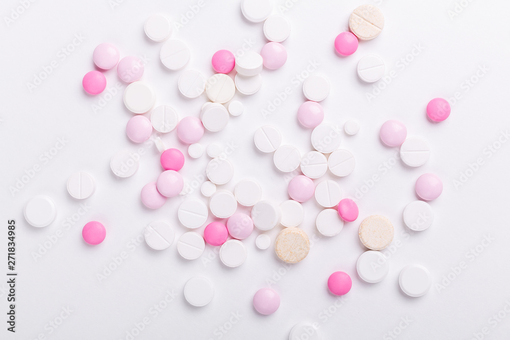 Pink and white pills on white background. Heap of assorted various medicine tablets and pills. Health care. Copy space. Top view.