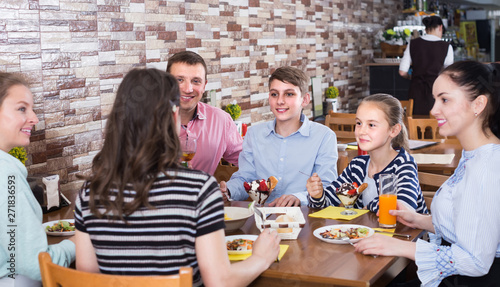 Group of adults and teenagers spending time in cafe