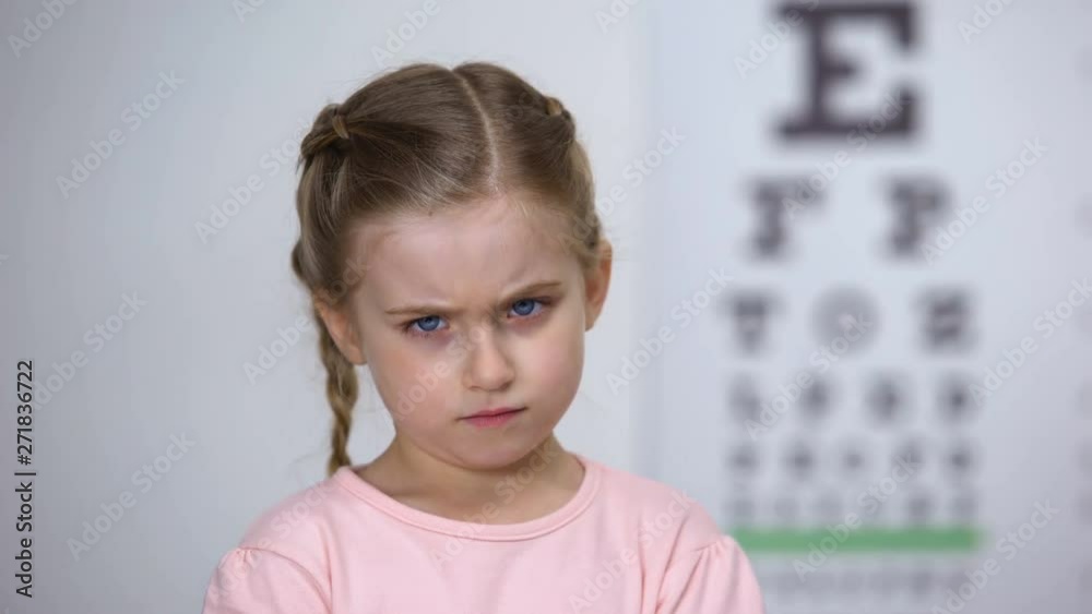 Displeased girl taking off glasses, uncomfortable spectacle frames, bad lens Displeased girl taking off glasses, uncomfortable spectacle frames, bad lens