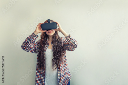 Smile young woman wearing using virtual reality VR glasses helmet headset on white background. Smartphone using with virtual reality goggles. Technology, simulation, hi-tech, videogame concept