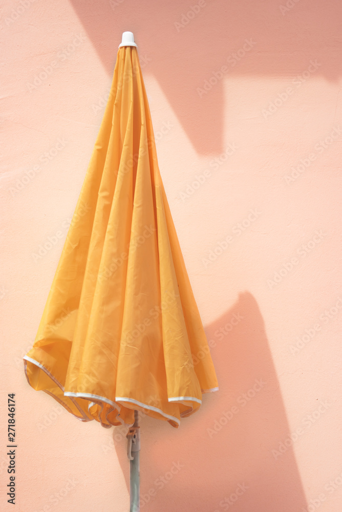 Yellow parasol on a pink wall Yellow parasol on a pink wall