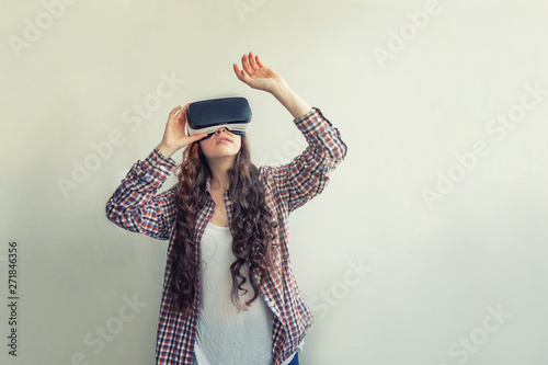 Smile young woman wearing using virtual reality VR glasses helmet headset on white background. Smartphone using with virtual reality goggles. Technology, simulation, hi-tech, videogame concept