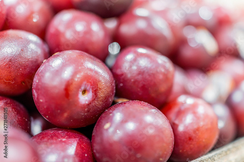 Macro closeup of display of red shiny plums