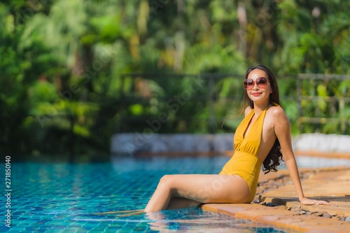 Portrait beautiful young asian woman leisure relax smile and happy around swimming pool in hotel resort