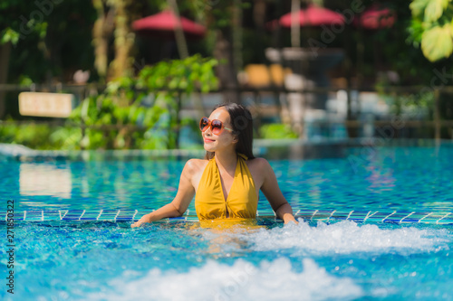 Portrait beautiful young asian woman leisure relax smile and happy around swimming pool in hotel resort