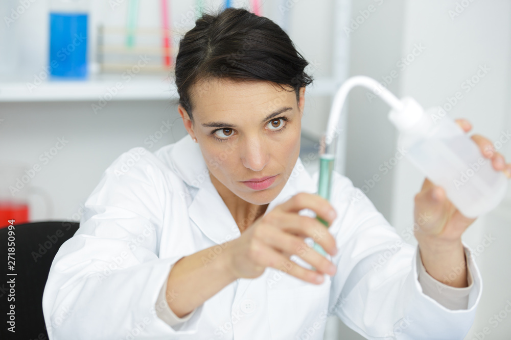 woman scientist adding liquid to test tube woman scientist adding liquid to test tube