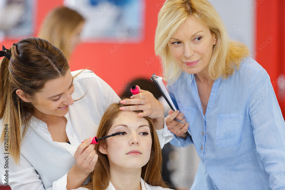 Fototapeta premium trainee beautician applying mascara to live model