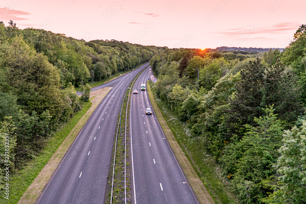 Two lane highway at sunset with cars overtaking van