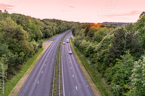 Two lane highway at sunset with cars overtaking van