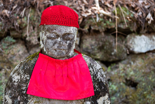 Famous red Jizo statue closeup in Kanmangafuchi Abyss, Nikko in Japan with bib protecting the dead photo