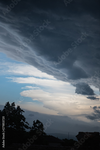 Dramatic morning sky with dark and white clouds, beautiful vertical cloudscape suitable for book cover, ominous atmosphere