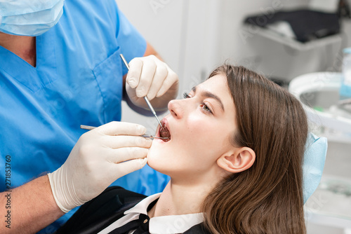 Doctor treats teeth. Medicine, health, stomatology concept. dentist treating a patient. . Young beautiful woman in the dentist chair at dental clinic.