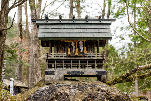 Small wooden shinto shrine in forest in Takayama Hida no Sato folk village in Gifu prefecture, Japan