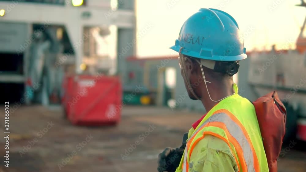 Seaman AB or Bosun on deck of vessel or ship , wearing PPE personal ...