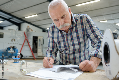 Fotografija pleasant senior man working with blueprint