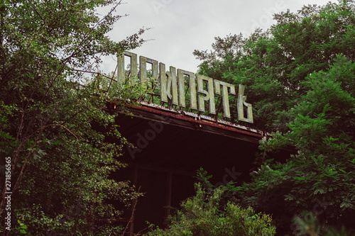 Chernobyl Exclusion Zone, Ukraine. Destroyed abandoned ghost city Pripyat ruins after disaster. Nuclear Power Plant atomic reactor sign. Lost town. Text translation: Pripyat.
