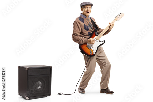 Cheerful senior man playing an electric guitar plugged into an amplifier photo