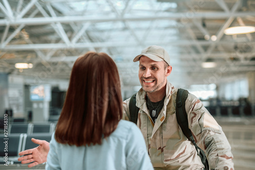 Cropped photo of American soldier in camouflage smiling to his wife