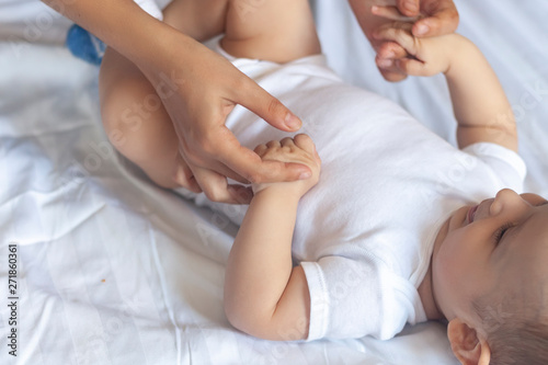 Baby massage. Mom doing gymnastics with kid. Mommy massaging cute baby boy. Moving baby's legs to help relieve constipation. Young mother doing exercises and movements to stimulate baby's bowels.