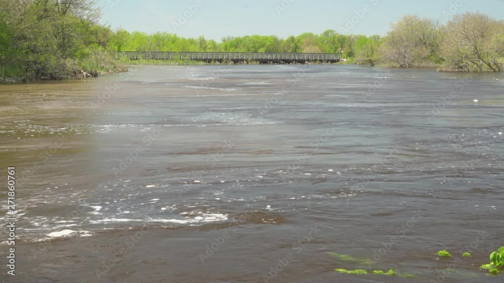 Flooded and turbulent Elkhorn River in Nebraska with a long trestle of the Cowboy Trail crossing Flooded and turbulent Elkhorn River in Nebraska with a long trestle of the Cowboy Trail crossing