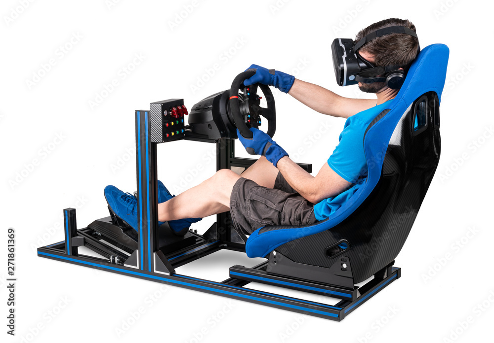 gamer in blue tshirt with VR virtual reality training on aluminum simulator rig video game racing. Motorsport car bucket seat steering wheel pedals isolated white background Stock
