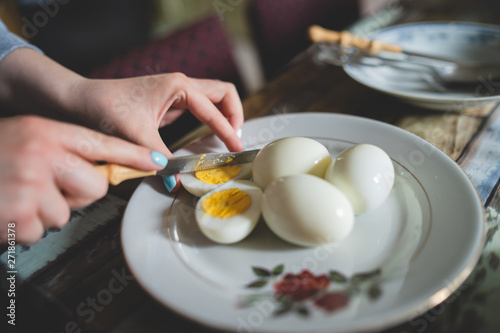 Close up on female hands woman girl cutting boiled egg at home domestic farm natural healthy organic food