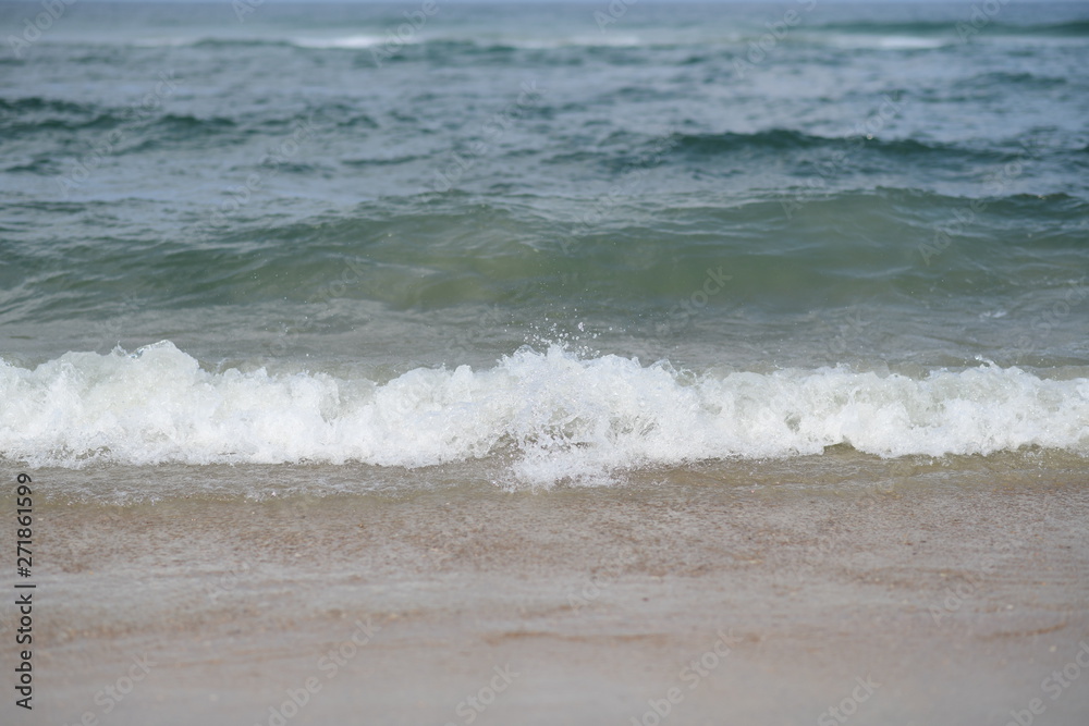 closeup on waves hitting the beach on a sunny summer day closeup on waves hitting the beach on a sunny summer day