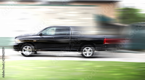 A black truck at high speed rides along the road  speed in motion