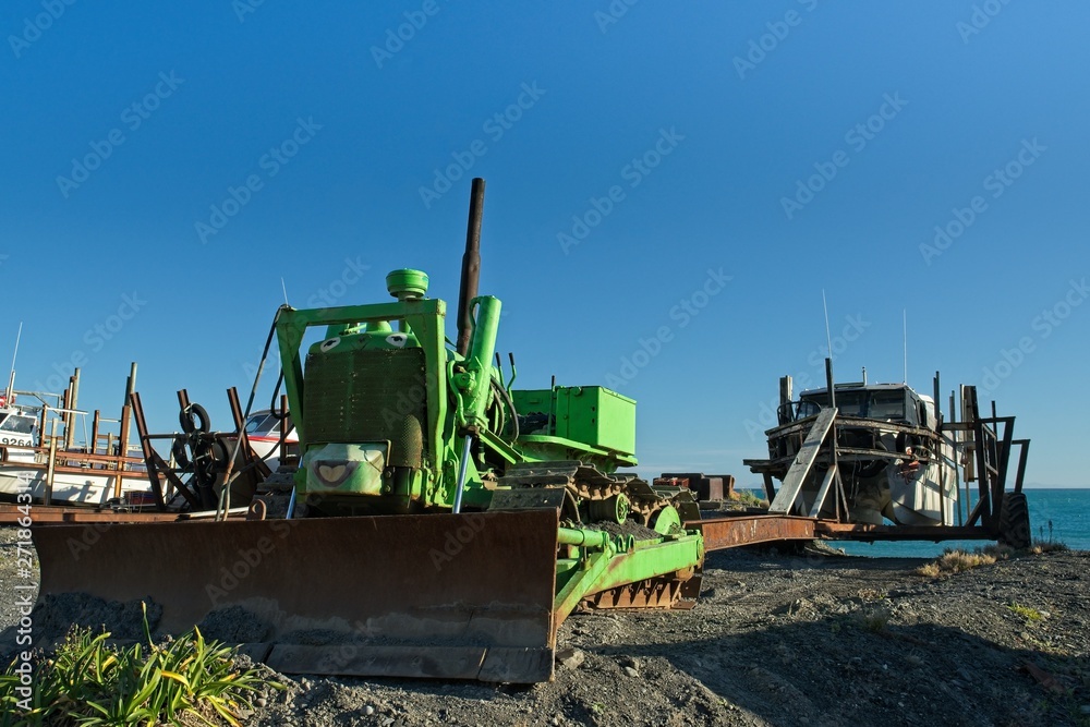 Bulldozer pulling a boat up the beach, Ngawi, New Zealand. Bulldozer pulling a boat up the beach, Ngawi, New Zealand.