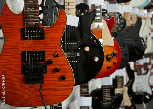 Row of different guitars in music store, closeup